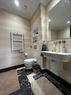a bathroom with a sink and a toilet and a mirror at Marrakech M Avenue terrasse jardin in Marrakech