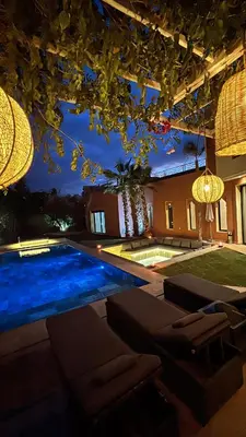 a house with a swimming pool at night at Villa M Piscine chauffée, Hammam sans vis à vis Marrakech in Marrakech