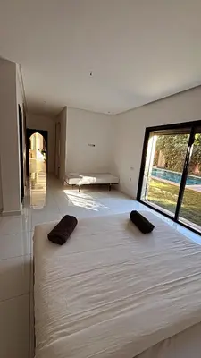 a large bed in a room with a large window at Villa M Piscine chauffée, Hammam sans vis à vis Marrakech in Marrakech