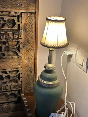 a green lamp sitting on a table next to a wall at Riad Dar Malwan Hotel and Massage in Marrakech