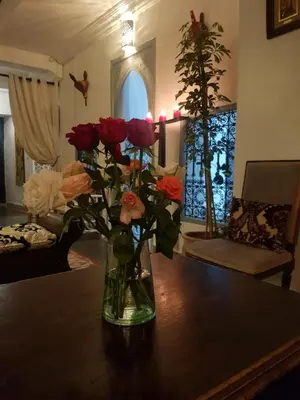 a vase of roses sitting on a table at Riad Dar Malwan Hotel and Massage in Marrakech