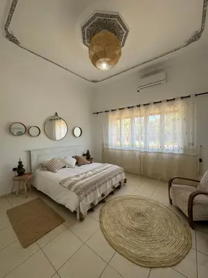 a bedroom with a large bed and a couch at Maison Jannate Louise in Marrakech