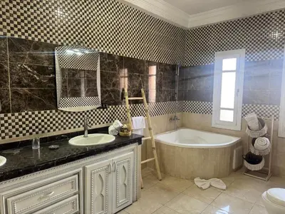 a bathroom with a tub and a sink and a bath tub at Maison Jannate Louise in Marrakech