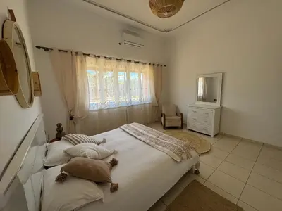 a bedroom with a large bed and a window at Maison Jannate Louise in Marrakech