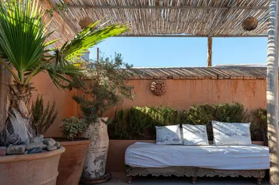a bed in a room with some plants and trees at Riad le Jardin de Mina in Marrakech