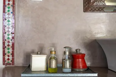 a table with two bottles of oil and a candle at Riad le Jardin de Mina in Marrakech