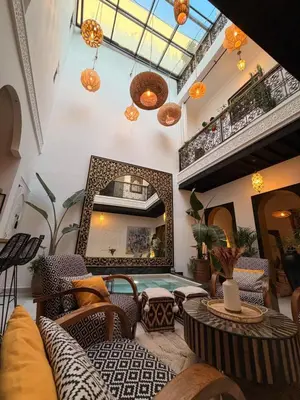a room with chairs and a table and a mirror at Magnifique Riad Julilu Privatise au coeur de la Medina 11P in Marrakech