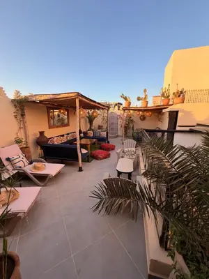 a patio with chairs and a couch on a building at Magnifique Riad Julilu Privatise au coeur de la Medina 11P in Marrakech