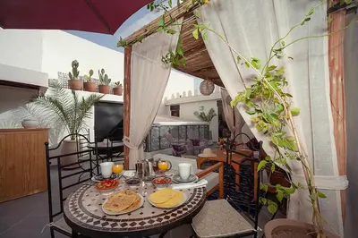 a table with plates of food on top of a balcony at Magnifique Riad Julilu Privatise au coeur de la Medina 11P in Marrakech