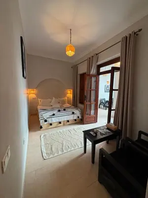a bedroom with a large bed and a table at Riad BB Marrakech in Marrakech
