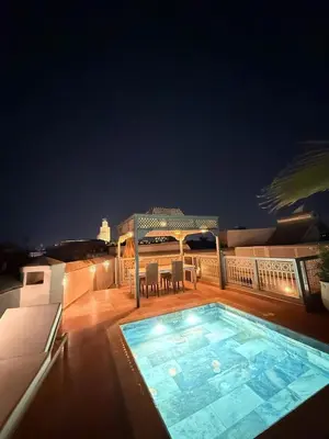 a swimming pool on a balcony at night at Riad BB Marrakech in Marrakech