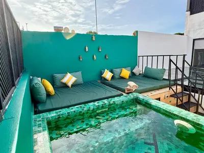 a couch on a balcony next to a swimming pool at Maison Meurisse JUJ in Marrakech