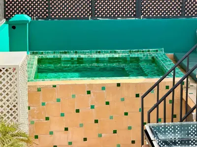 a large swimming pool with green water in a building at Maison Meurisse JUJ in Marrakech