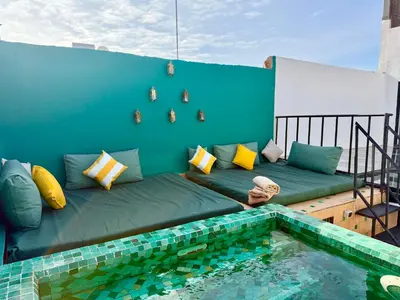 a couch on a balcony next to a swimming pool at Maison Meurisse JUJ in Marrakech