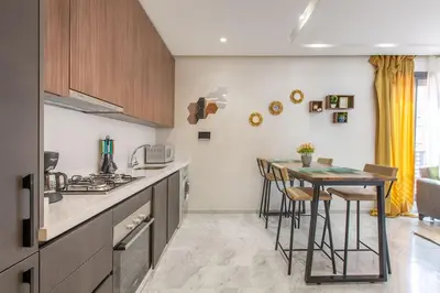 a kitchen with a counter and a table with stools at New! Marvellous'n modern flat in Marrakech