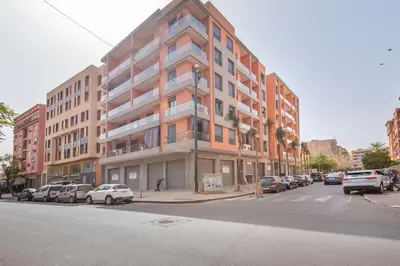 a large building on a city street with parked cars at New! Marvellous'n modern flat in Marrakech