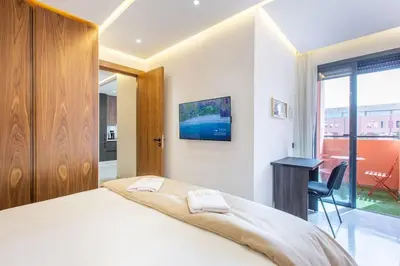 a bedroom with a bed and a desk and a window at New! Marvellous'n modern flat in Marrakech