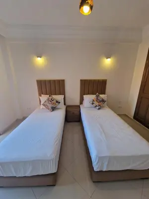 two beds sitting next to each other in a room at appartement de luxe face la marllette in Marrakech