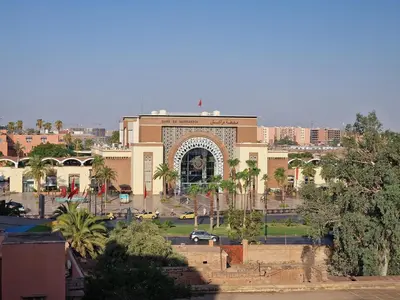 a building with an arch in the middle of a city at appartement de luxe face la marllette in Marrakech