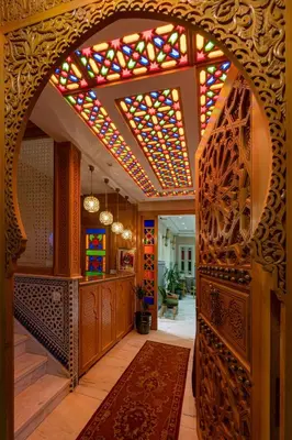 a hallway with an archway with a stained glass ceiling at HOTEL RIAD CHAMI in Marrakech
