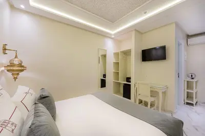 a bedroom with a white bed and a desk at HOTEL RIAD CHAMI in Marrakech