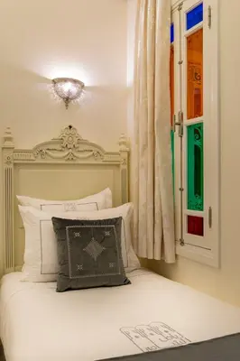a bedroom with a white bed and a window at HOTEL RIAD CHAMI in Marrakech