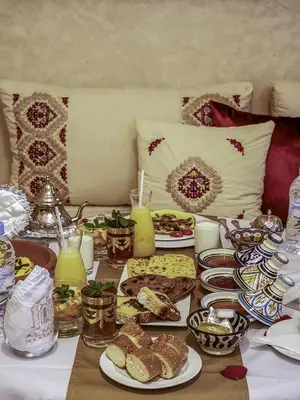 a table topped with plates of food and drinks at Riad Almisk in Marrakech