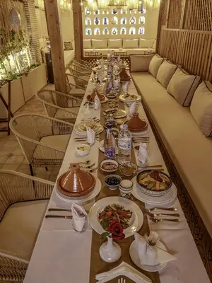 a long table with plates of food on it at Riad Almisk in Marrakech
