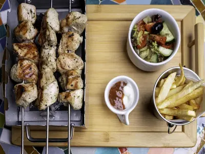 a tray of food with french fries and a salad at Riad Almisk in Marrakech