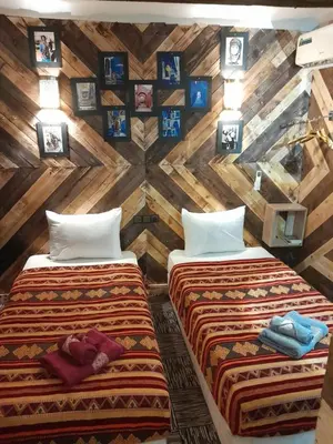 two beds in a room with wooden walls at studio funny house près de la grande place jamaa el fna in Marrakech