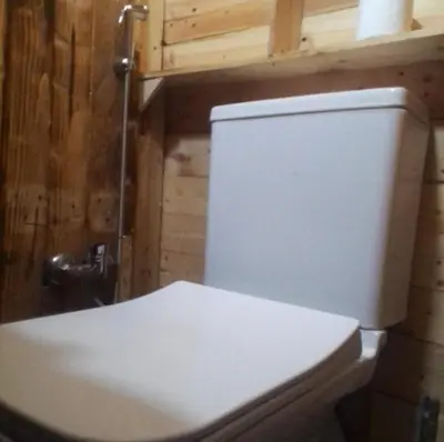 a white toilet in a bathroom with wooden walls at studio funny house près de la grande place jamaa el fna in Marrakech