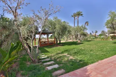 a park with a gazebo and trees and grass at Villa May sur le Golf de la Palmeraie with Cooker and Butler included in Marrakech