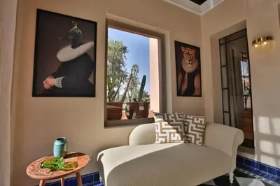 a living room with a chair and a table at Villa May sur le Golf de la Palmeraie with Cooker and Butler included in Marrakech
