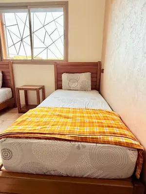 a bedroom with a bed with a checkered blanket on it at Appartement en résidence privée in Marrakech