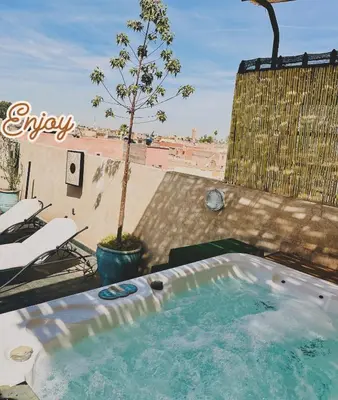 a hot tub on a patio with a tree at DAR Riad Jomana in Marrakech