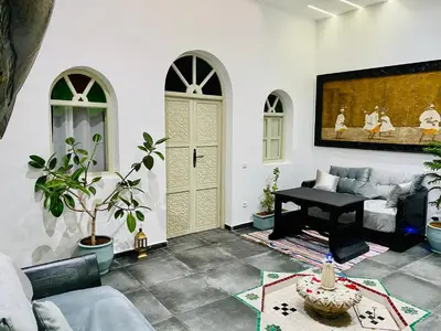 a living room with a table and a piano at DAR Riad Jomana in Marrakech