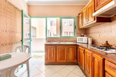 a kitchen with wooden cabinets and a table in it at Espace Harmony in Marrakech