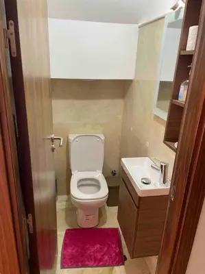 a small bathroom with a toilet and a sink at Duplex Cosy dans résidence avec piscine in Marrakech