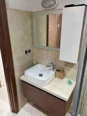 a bathroom with a sink and a mirror at Duplex Cosy dans résidence avec piscine in Marrakech
