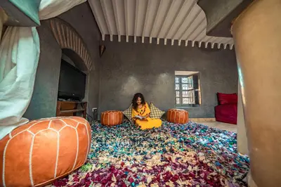 a woman sitting on a couch in a room with pumpkins at Riad Azawan in Marrakech