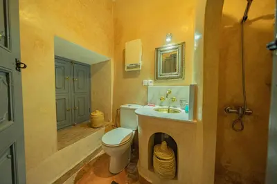a bathroom with a toilet and a sink and a mirror at Riad Azawan in Marrakech
