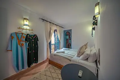 a bedroom with a bed and a window at Riad Azawan in Marrakech