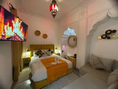 a bedroom with a large bed and a couch at RIAD KECHMARA in Marrakech