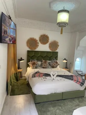 a bedroom with a large bed with hats on the wall at RIAD KECHMARA in Marrakech