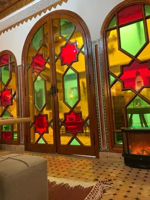 a living room with a large stained glass door at RIAD KECHMARA in Marrakech