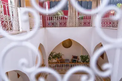 a room with red and white walls and balconies at Riad Petite Rose in Marrakech