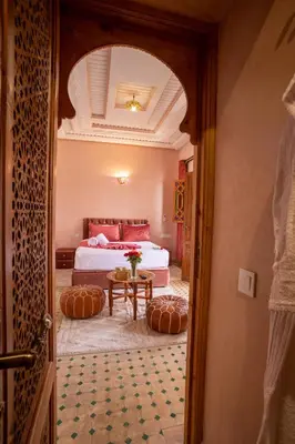 a bedroom with a bed and a table in a room at Riad Petite Rose in Marrakech