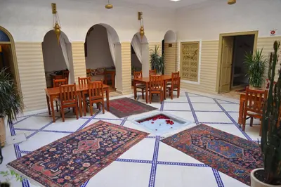 a room with tables and chairs and rugs on the floor at Riad Marana Hotel & Spa in Marrakech