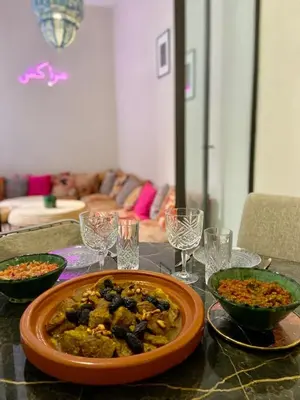 a table with a plate of food and wine glasses at Riad Doum Collection 1 in Marrakech