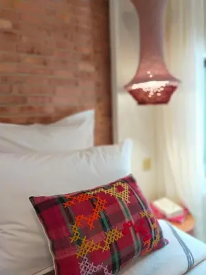 a bedroom with a bed with a pillow and a lamp at Riad Doum Collection 1 in Marrakech